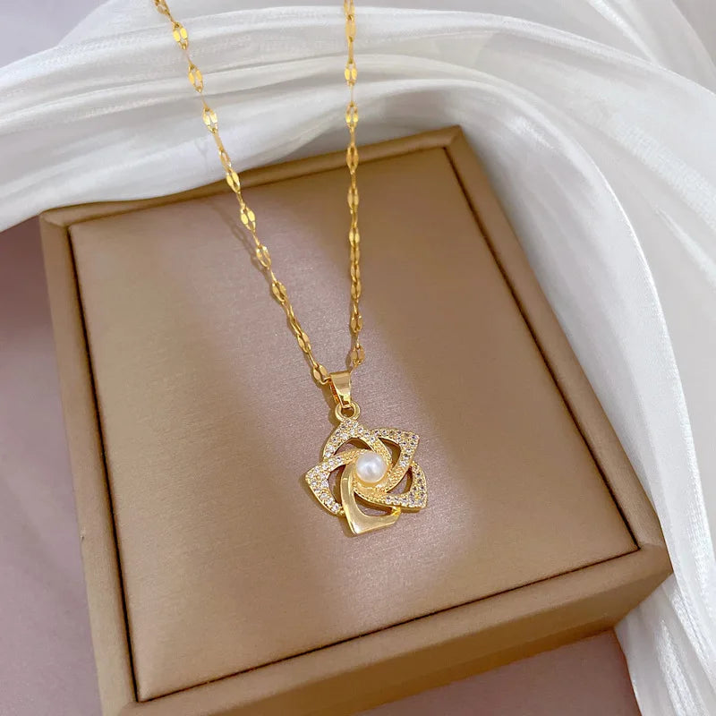 Elegant necklace featuring a delicate floral pendant with a luminous pearl at its center and surrounded by sparkling clear stones, presented on a beige jewelry box against a soft white draped fabric. Feminine and graceful pearl jewelry.
