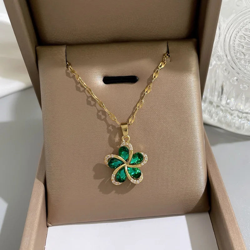 Elegant necklace with a sparkling green floral pendant, displayed beautifully in a neutral-colored jewelry box. The piece features emerald-like stones and diamond-like accents, perfect as a gift for women who love delicate and stylish accessories.