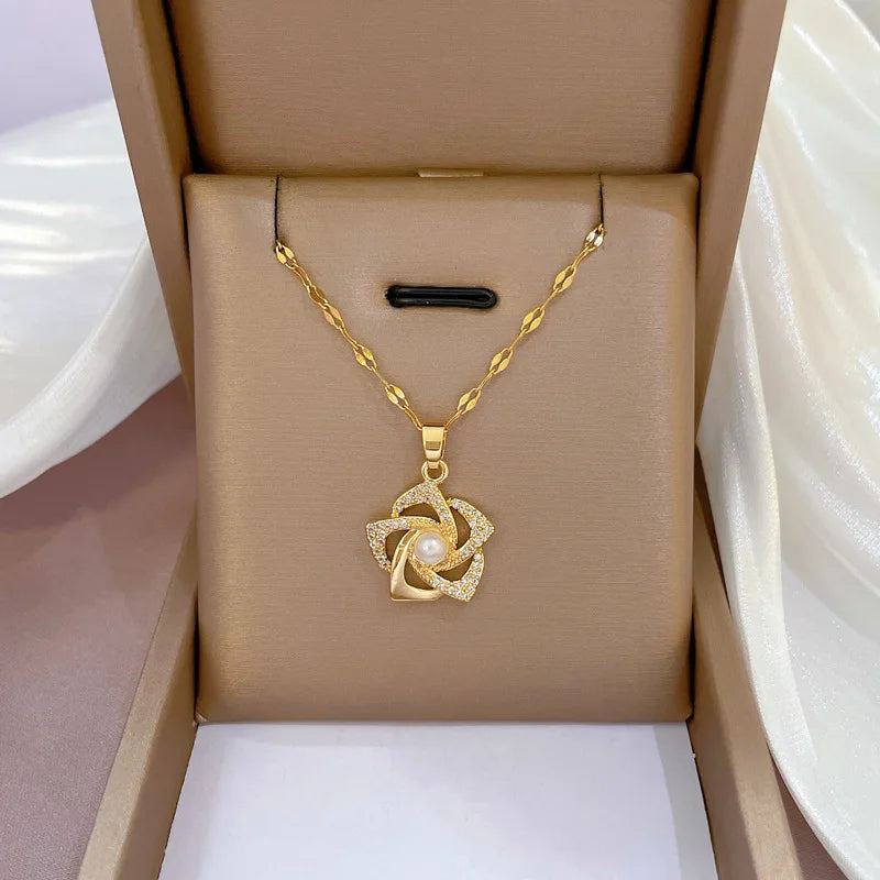 An elegant necklace with a stylish floral pendant featuring a luminous central pearl and sparkling cubic zirconia accents, displayed beautifully in a beige jewelry box. Perfect gift for women.