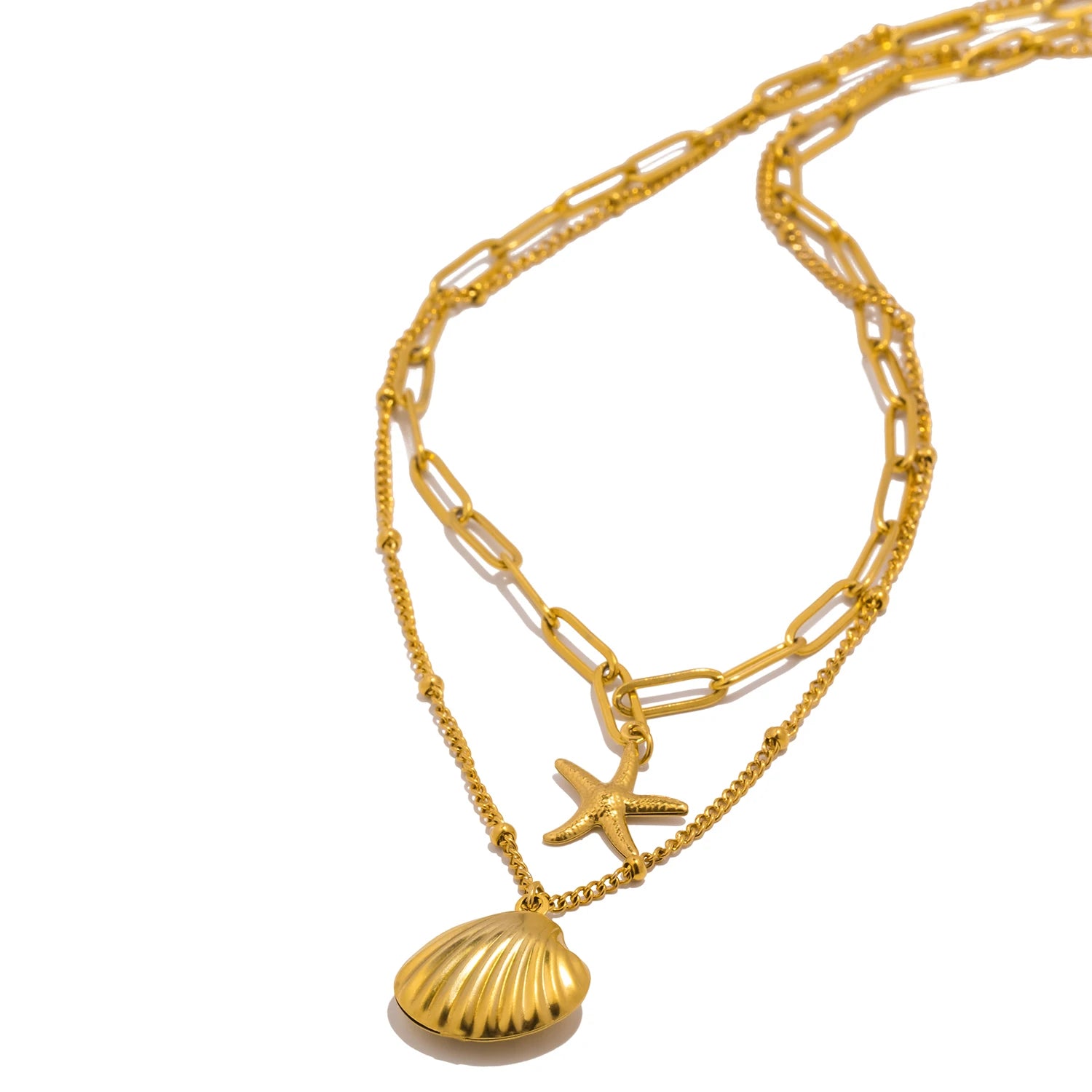 A stylish gold layered necklace featuring a detailed seashell pendant and a starfish charm, with a combination of paperclip and beaded chains, isolated on a clean white background. Trendy beach jewelry.